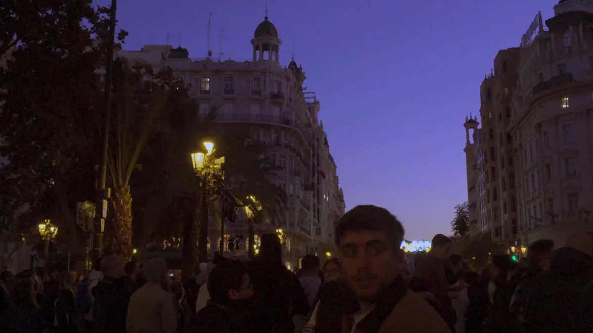 Calle de Valencia al anochecer con palmeras y luces cálidas